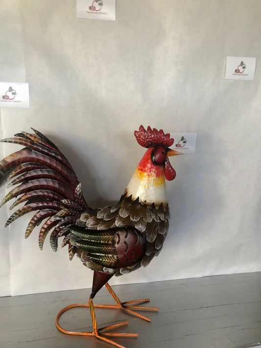 Gallo decorativo in metallo dipinto a mano, ideale per arredare giardino, terrazzo, balcone, portico o ambienti interni in stile rustico e country. Realizzato interamente in metallo con dettagli tridimensionali in rilievo, presenta una ricca lavorazione delle piume e una finitura anticata dai colori vivaci che dona carattere e originalità a qualsiasi spazio. La struttura autoportante garantisce stabilità e permette di posizionarlo facilmente senza necessità di supporti. Perfetto come complemento d'arredo pe