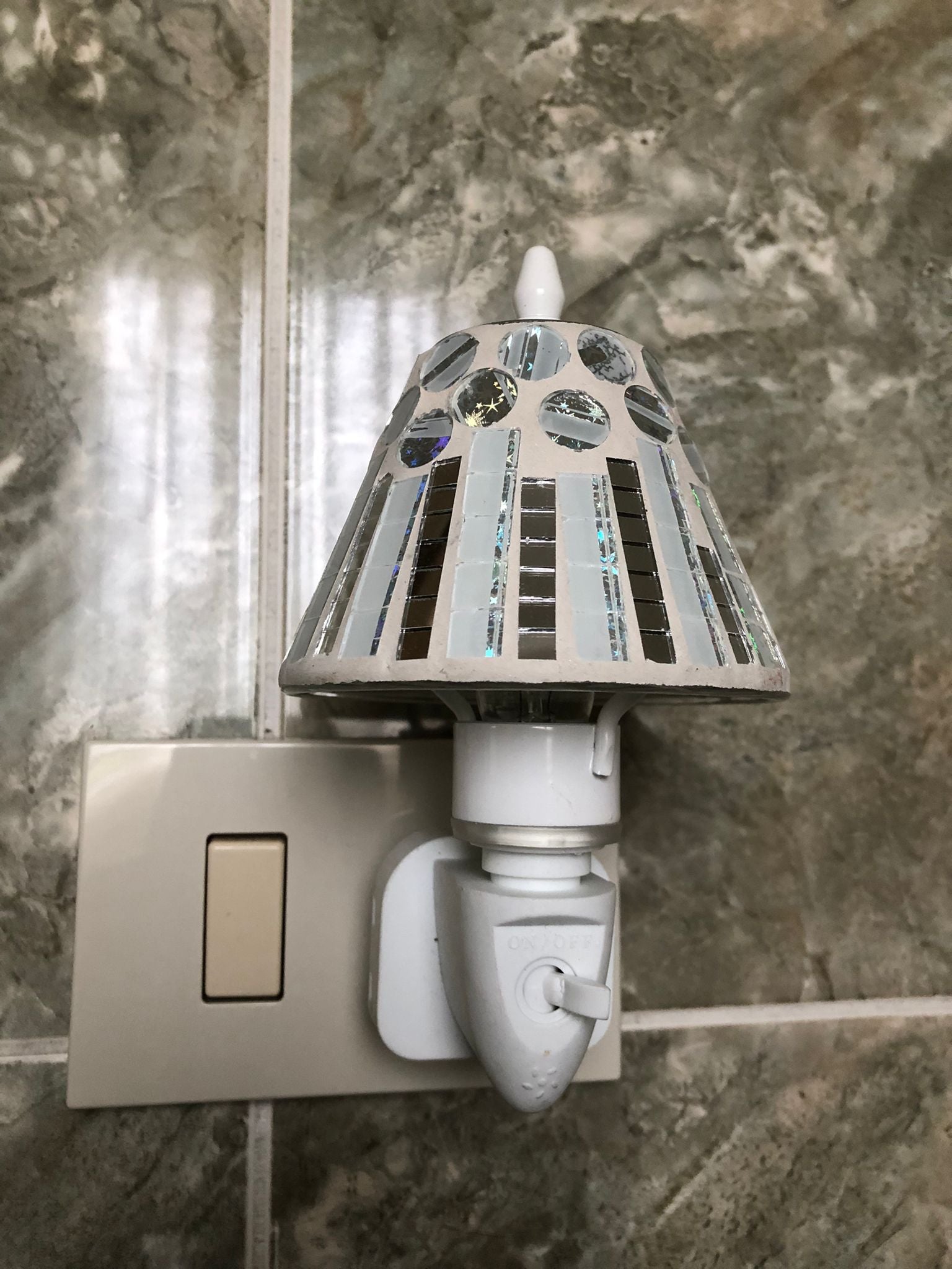 Lampada notturna LED a risparmio energetico

Paralume mosaico con design unico ed elegante

Ideale per camera da letto, bagno, corridoio e cameretta

Facile installazione: si collega direttamente alla presa elettrica

Luce calda e soffusa, perfetta per relax e sicurezza notturna